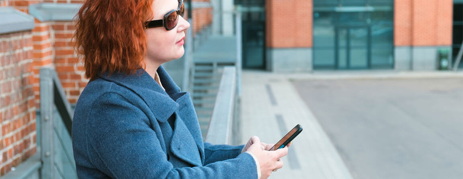 mujer ciega sosteniendo un teléfono móvil