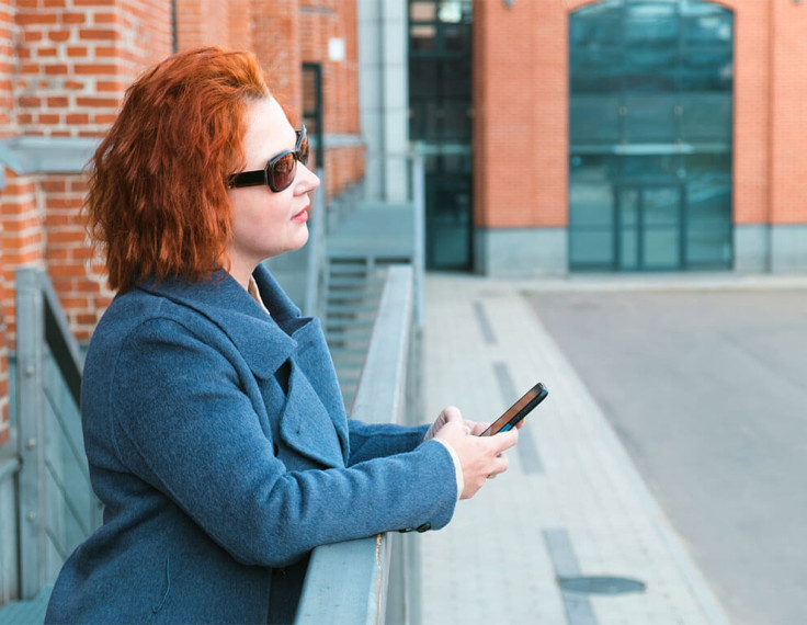 mujer ciega sosteniendo un teléfono móvil